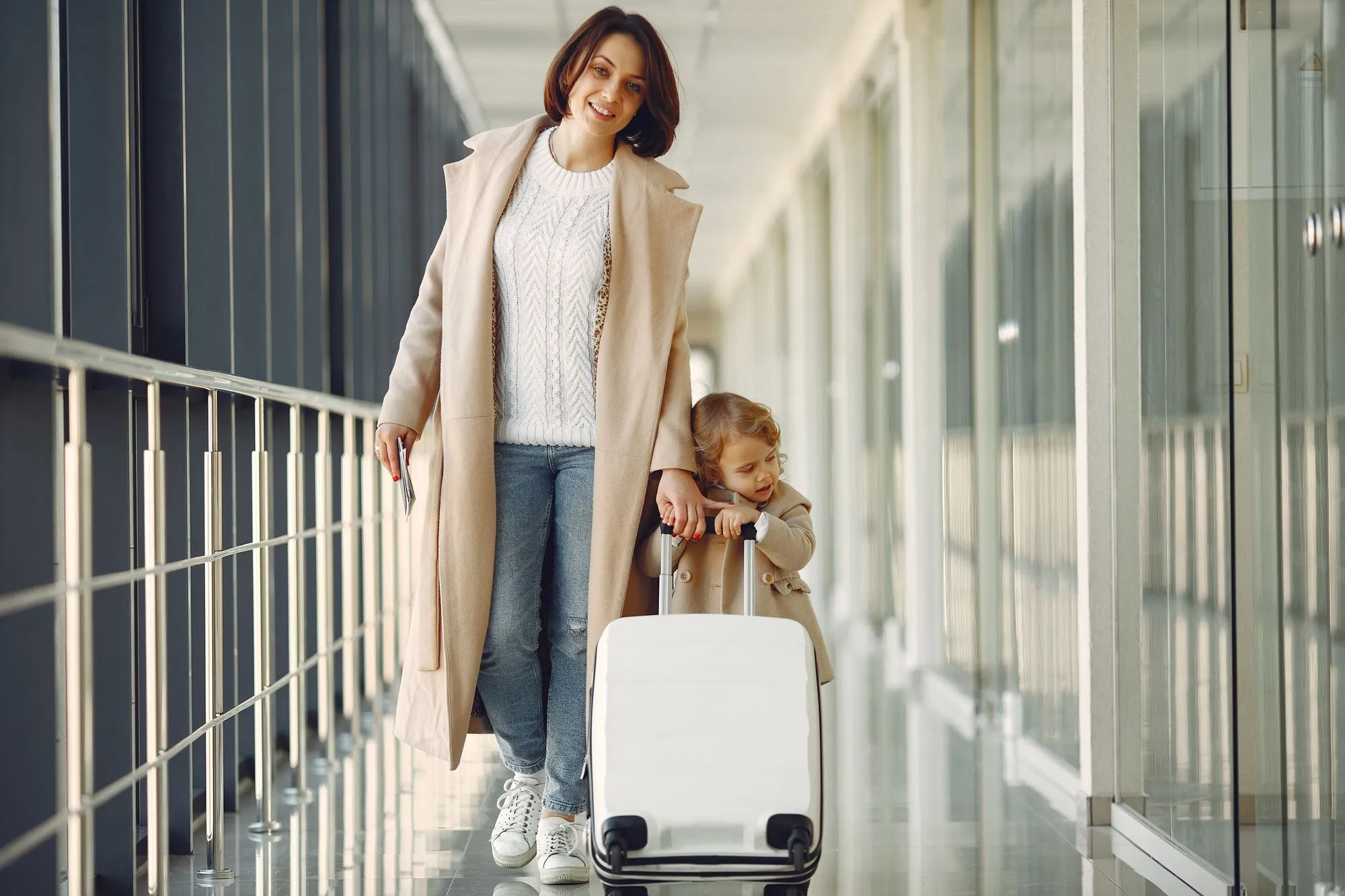 A family walking through an airport with their luggage.