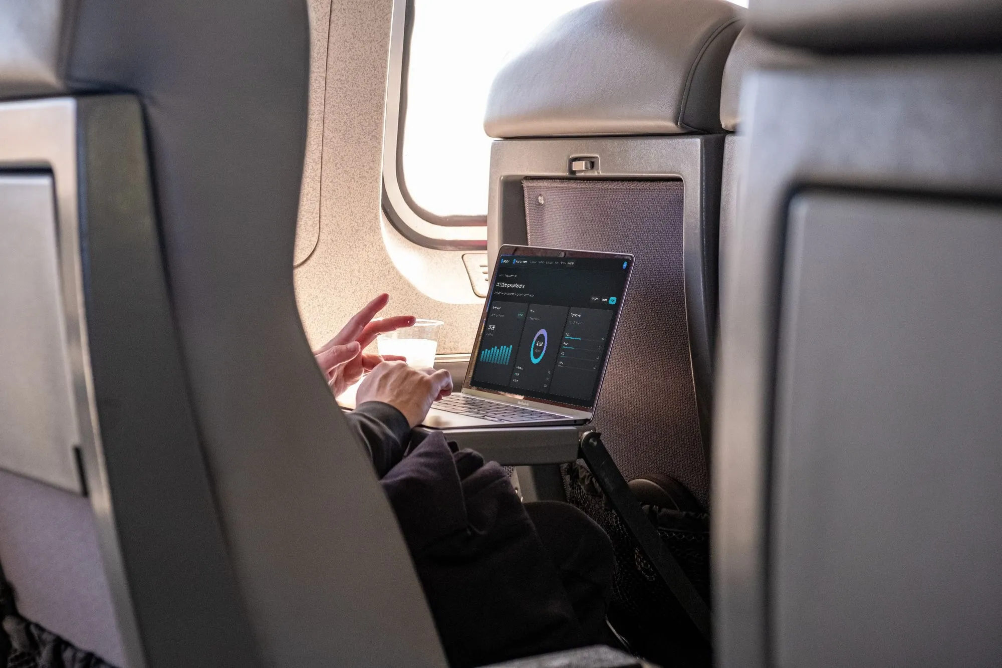 A passenger reviewing charts on a laptop in flight.