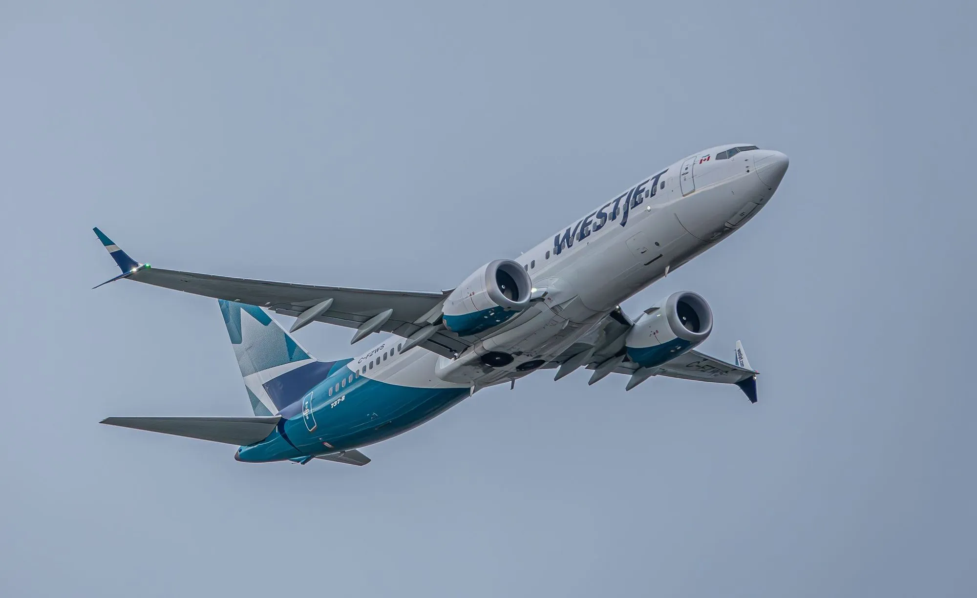 A WestJet Boeing 737 climbing overhead.
